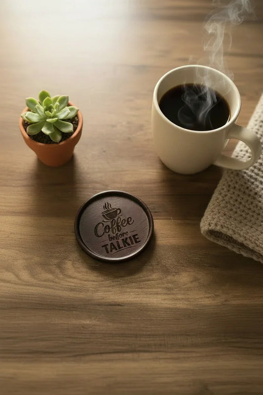 Steaming coffee cup on a wooden table with a coaster and small plant