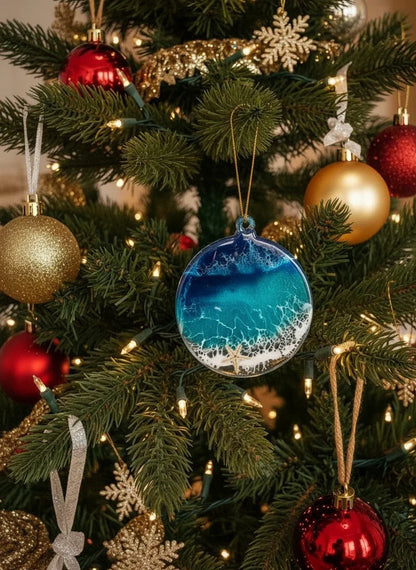 Handmade ocean-inspired resin ornament with blue waves and coastal details on a Christmas tree